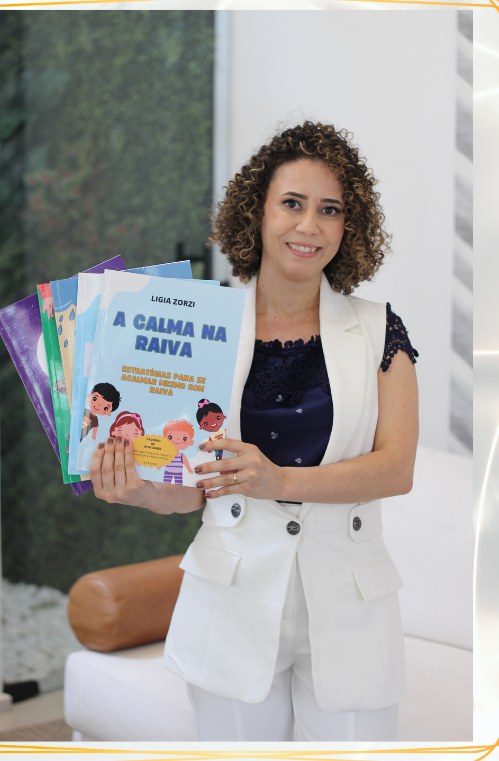 Lígia Nascimento segurando os livros da coleção Emoções e Corpo